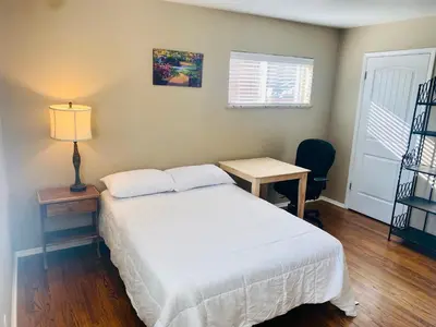 a bedroom with a bed and a table and a lamp at Master Bedroom and Bath in Arvada