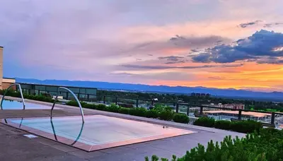 a swimming pool on top of a building with a sunset at Cherry Creek Rooftop Oasis in Denver