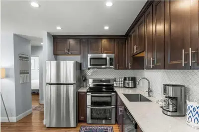 a kitchen with wooden cabinets and a stainless steel refrigerator at New Listing 3BR Frisco Condo - Ski and Bus Access in Frisco