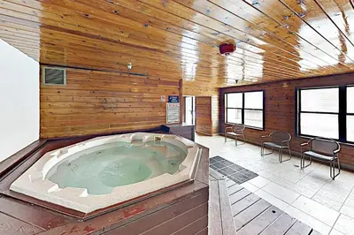 a large hot tub in a room with a wooden wall at Downtown Luxury + Hot Tubs; Walkable Winter Park in Winter Park