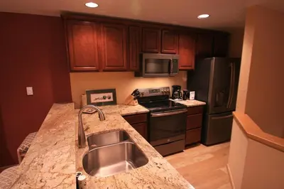 a kitchen with a sink and a counter top at Downtown Luxury + Hot Tubs; Walkable Winter Park in Winter Park