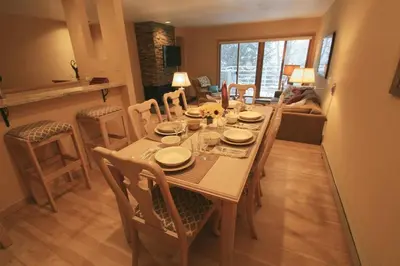 a dining table and chairs in a living room at Downtown Luxury + Hot Tubs; Walkable Winter Park in Winter Park