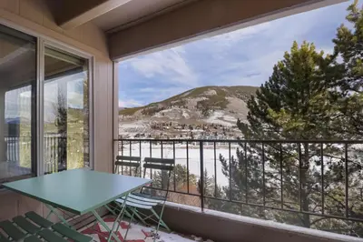 a balcony with a table and chairs and a view at 317 Lodge at Lake Dillon condo in Dillon