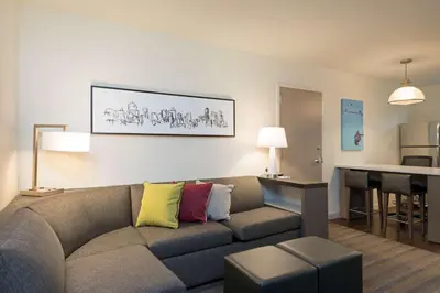a living room with a couch with colorful pillows at Hyatt House Denver Downtown in Denver