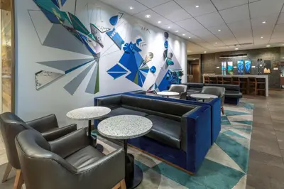 a waiting room with a couch and tables and chairs at Hyatt Place Denver Downtown in Denver