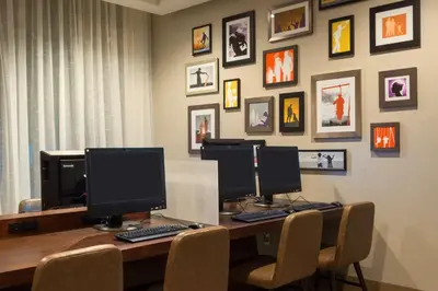 a desk with three computer monitors on top of it at Hyatt Place Denver Downtown in Denver