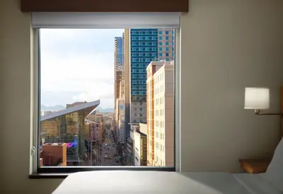 a view of a city from a bedroom window at Hyatt Place Denver Downtown in Denver
