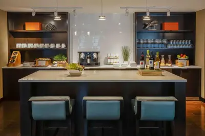 a bar with blue chairs and a counter with bottles of wine at Hyatt Regency Aurora-Denver Conference Center in Aurora