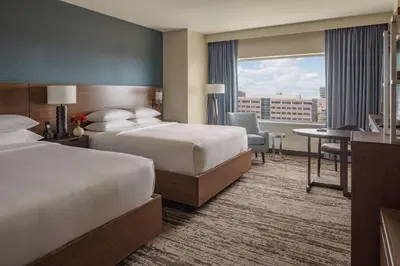 a hotel room with two beds and a desk at Hyatt Regency Aurora-Denver Conference Center in Aurora