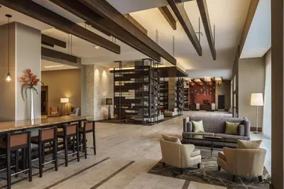 a lobby with a bar and chairs and a wine cellar at Hyatt Regency Aurora-Denver Conference Center in Aurora
