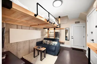 a living room with a blue couch and a loft at Townhouse in Santa Fe Arts District in Denver