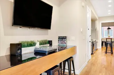 a living room with a bar with a television on the wall at Townhouse in Santa Fe Arts District in Denver