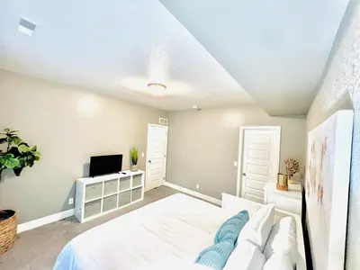 a bedroom with a white bed and a tv at Entire Fully Equipped Basement Guest Apartment Home in DEN