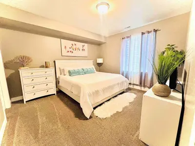 a bedroom with a bed and a dresser and a window at Entire Fully Equipped Basement Guest Apartment Home in DEN