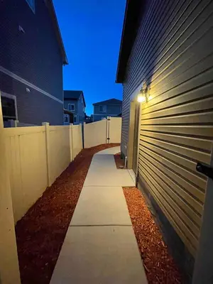 a sidewalk next to a building with a fence at Entire Fully Equipped Basement Guest Apartment Home in DEN
