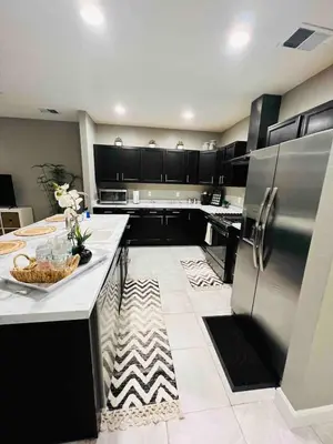a kitchen with black cabinets and a white floor at Entire Fully Equipped Basement Guest Apartment Home in DEN