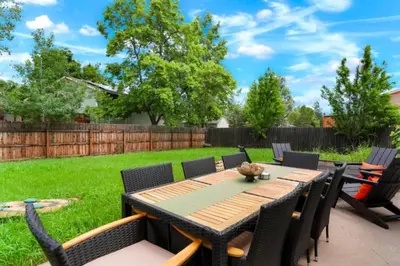 a patio with a wooden table and chairs at Game Room • Fire Pit • Arcade • Outdoor Dining in Arvada