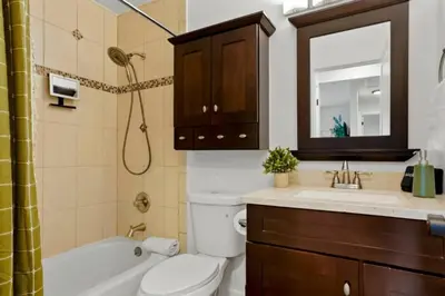 a bathroom with a toilet and a sink and a mirror at Game Room • Fire Pit • Arcade • Outdoor Dining in Arvada