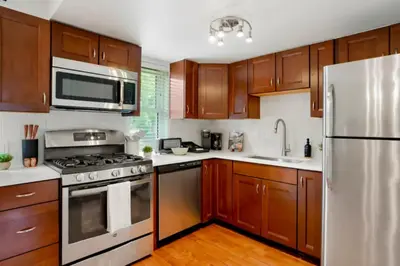 a kitchen with wooden cabinets and stainless steel appliances at Game Room • Fire Pit • Arcade • Outdoor Dining in Arvada