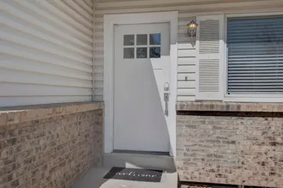 a white door on a house with a brick wall at Game Room • Fire Pit • Arcade • Outdoor Dining in Arvada