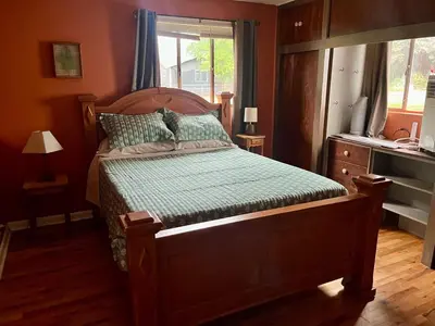 a bedroom with a wooden bed with a window at Little Brick House- pet friendly in Loveland