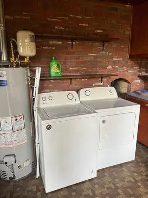 two washing machines sitting next to a brick wall at Little Brick House- pet friendly in Loveland