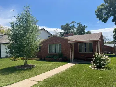 a brick house with a tree in the yard at Little Brick House- pet friendly in Loveland
