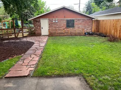 a yard with a fence and a house at Little Brick House- pet friendly in Loveland