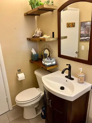 a bathroom with a toilet and a sink and a mirror at Little Brick House- pet friendly in Loveland
