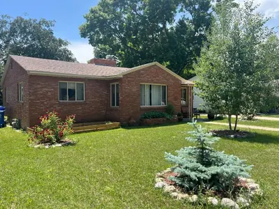 a brick house with a tree in the yard at Little Brick House- pet friendly in Loveland