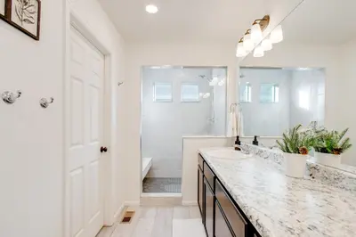 a white bathroom with a sink and a mirror at Home Gym and Fenced Backyard Aurora Family Home! in Aurora