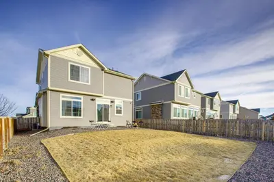 a house with a fence in front of a yard at Home Gym and Fenced Backyard Aurora Family Home! in Aurora