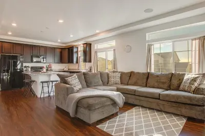 a living room with a couch and a kitchen at Home Gym and Fenced Backyard Aurora Family Home! in Aurora