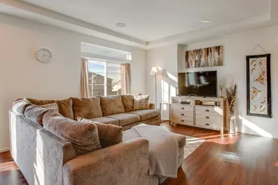 a living room with a couch and a flat screen tv at Home Gym and Fenced Backyard Aurora Family Home! in Aurora
