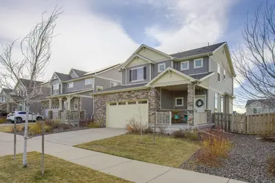 a gray house with a white garage at Home Gym and Fenced Backyard Aurora Family Home! in Aurora