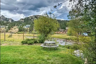 a picnic table in the grass in a field at Estes Escape-Walk Downtown - Free Mountain Coaster in Estes Park