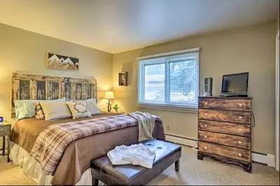 a bedroom with a bed and a dresser and a television at Estes Escape-Walk Downtown - Free Mountain Coaster in Estes Park