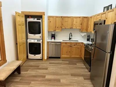 a kitchen with wooden cabinets and stainless steel appliances at Renovated 3BR Mountain Condo - Kids Ski Free condo in Keystone