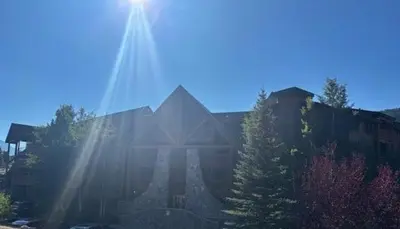 a large building with the sun shining on it at Renovated 3BR Mountain Condo - Kids Ski Free condo in Keystone