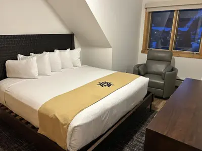 a hotel room with a bed and a chair at Renovated 3BR Mountain Condo - Kids Ski Free condo in Keystone