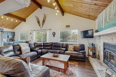 a living room with leather furniture and a fireplace at The Meandering Moose in Grand Lake