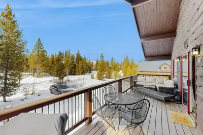 a balcony with a table and chairs and a view at The Meandering Moose in Grand Lake