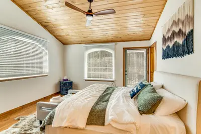 a bedroom with a bed and a ceiling fan at Wooded Retreat with Private Hot Tub in Evergreen in Evergreen