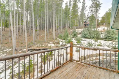 a deck with a view of a forest of trees at Wooded Retreat with Private Hot Tub in Evergreen in Evergreen