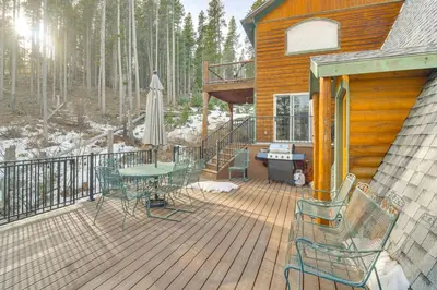 a deck with a table and chairs on a cabin at Wooded Retreat with Private Hot Tub in Evergreen in Evergreen