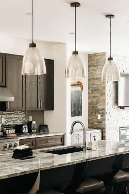 a kitchen with a counter and two pendant lights at Modern Mountain Townhome - Rooftop Hot Tub in Silverthorne