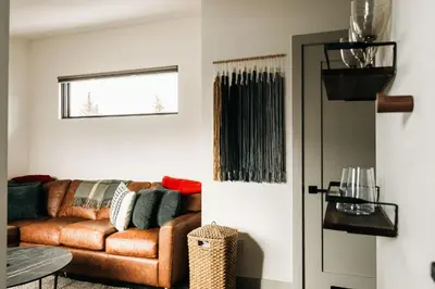 a living room with a brown couch and a window at Modern Mountain Townhome - Rooftop Hot Tub in Silverthorne