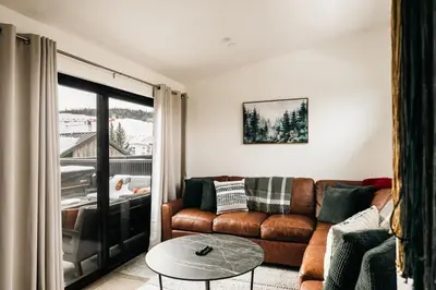a living room with a couch and a table at Modern Mountain Townhome - Rooftop Hot Tub in Silverthorne