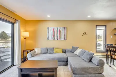 a living room with a couch and a table at Cozy Condo Steps to Free Winter Park Shuttle! in Fraser