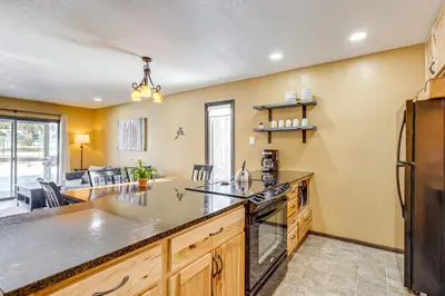 a kitchen with a large counter and a living room at Cozy Condo Steps to Free Winter Park Shuttle! in Fraser